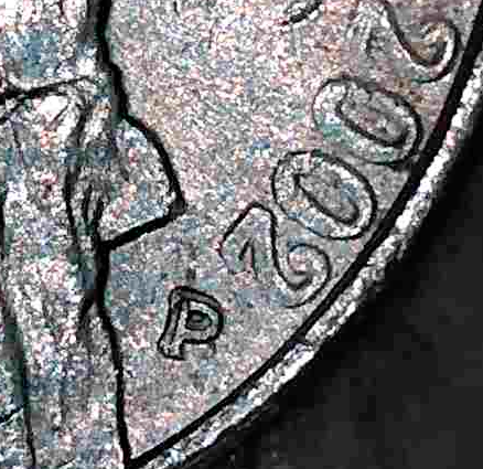 Close-up of a 2002 Jefferson nickel mintmark with machine doubling, showing shelf-like distortion.