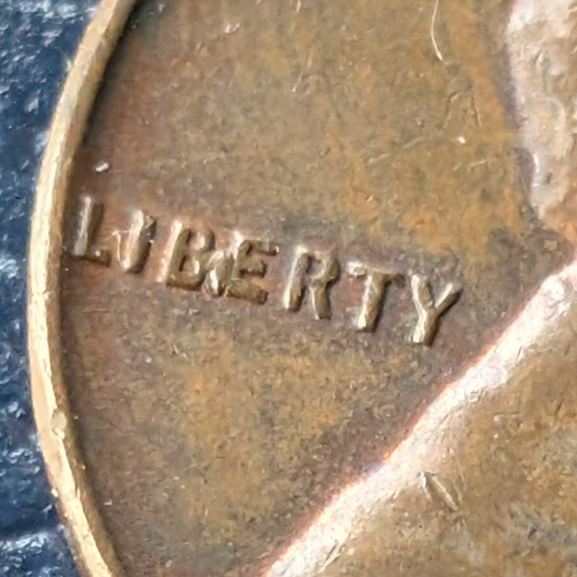 Close-up of 1955-D Lincoln cent showing a raised die crack between the B and E of LIBERTY.