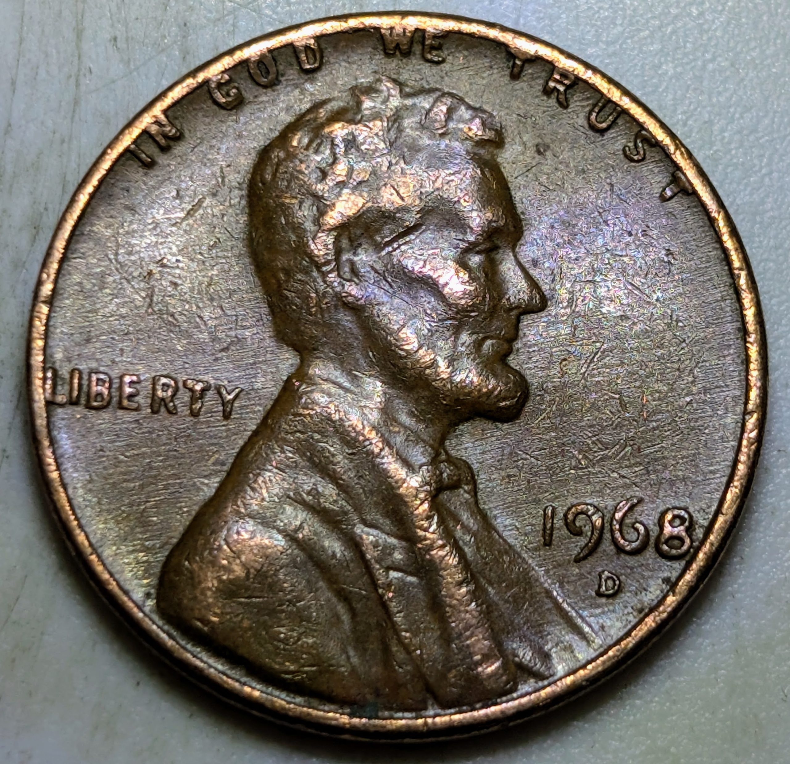 Another 1968-D cent showing the same pushed-in rim distortion. The flattened motto and spread lettering are caused by a clamp or vise after minting.