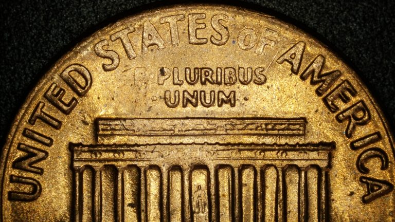 Close-up photo of a 1972 S Lincoln Memorial cent reverse showing a grease filled die. The words E PLURIBUS UNUM and parts of the upper Memorial detail appear faint and incomplete, with a soft, washed-out look due to debris blocking the strike.