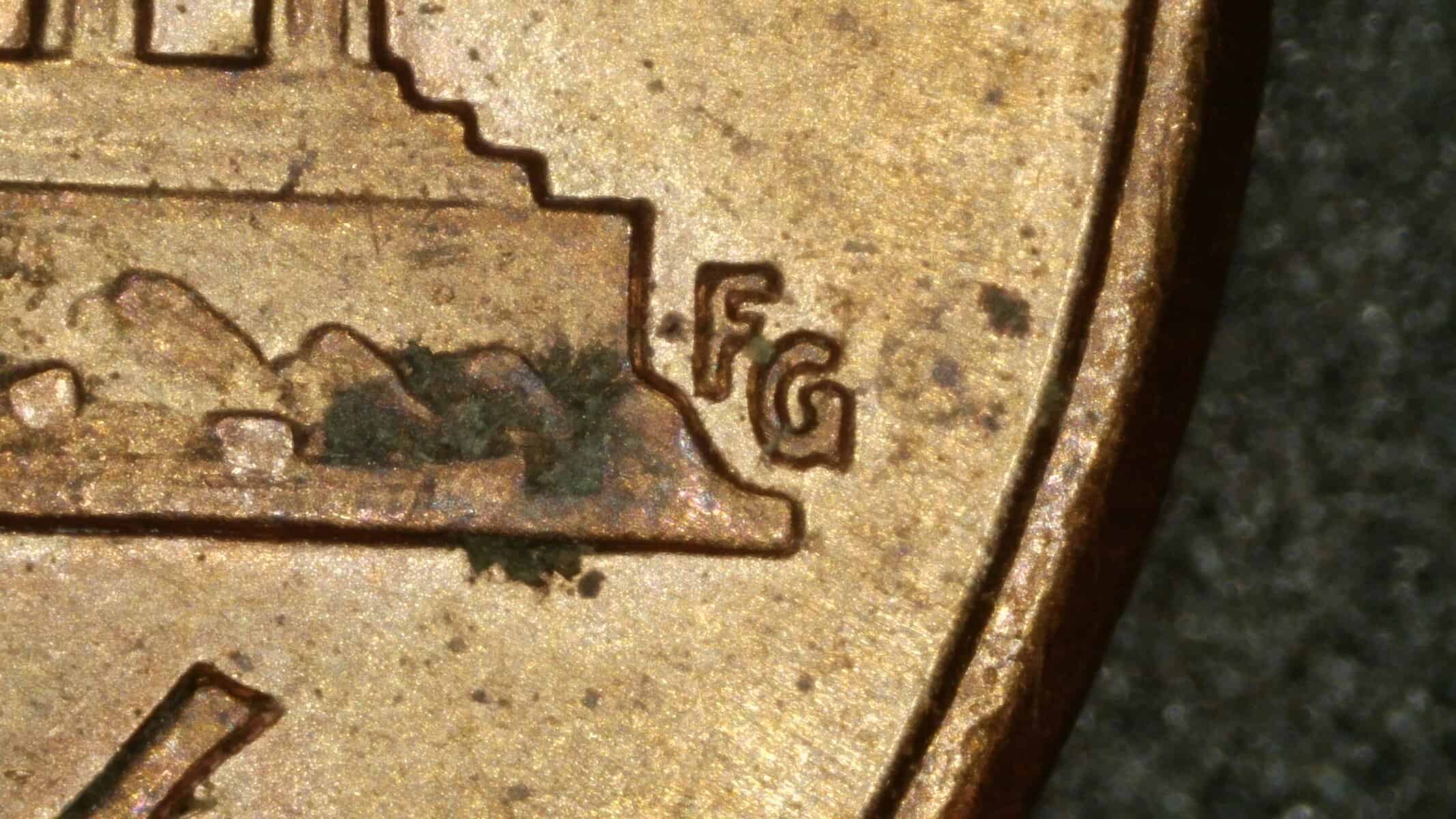 Close-up of FG initials on 2000 Lincoln cent Wide AM showing the distinctive inner curve of the G